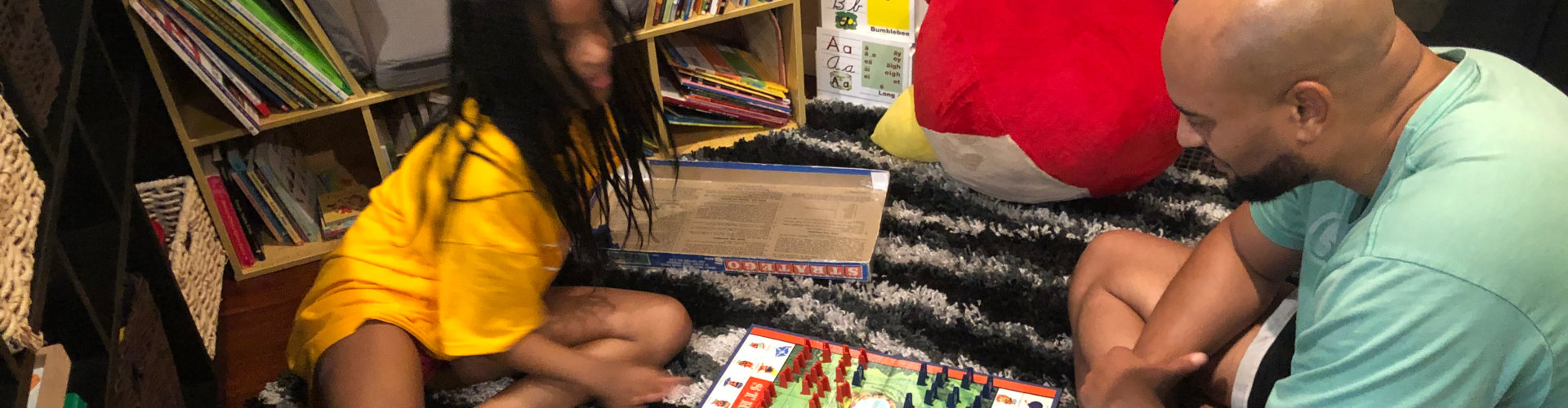 a kid and her teacher playing board games